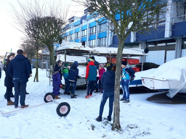 Bei Schnee und Eis zogen die Kinder ein Boot für das Kentertraining aus dem Opti-Gestell.