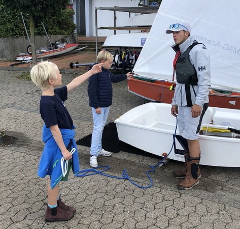 erklärt dann, wie ein Opti segelfertig gemacht wird.